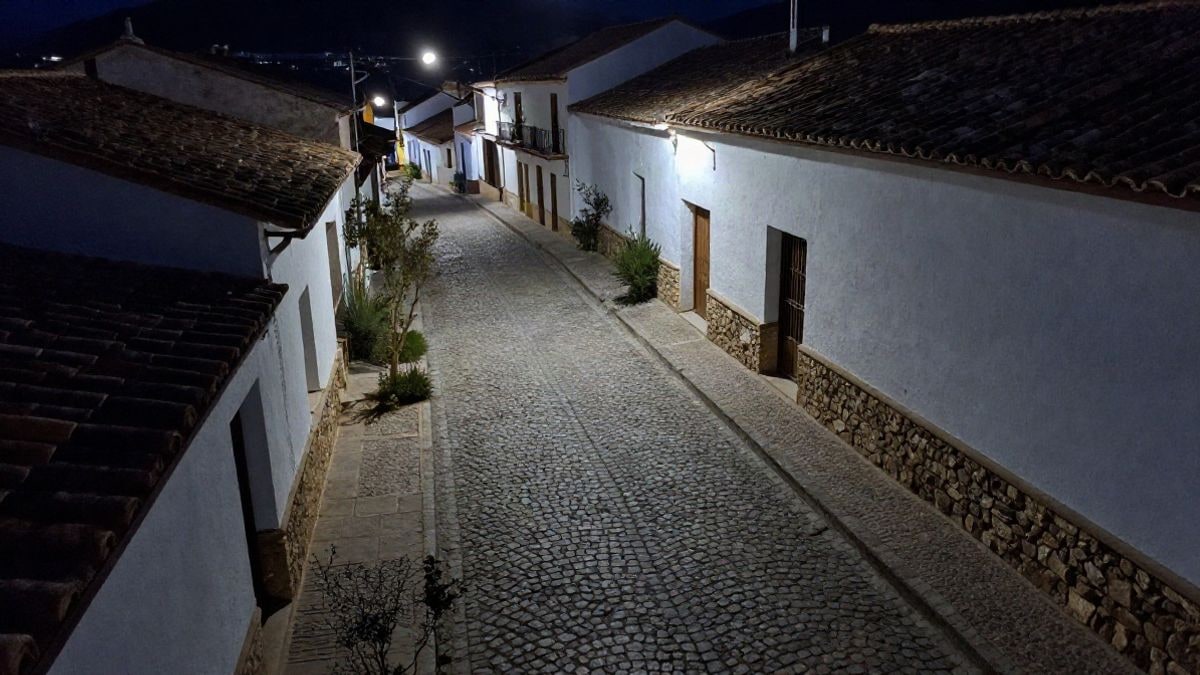 Imagen ilustrativa: vista cenital de una calle estrecha y encalada de un pueblo de montaña durante la noche