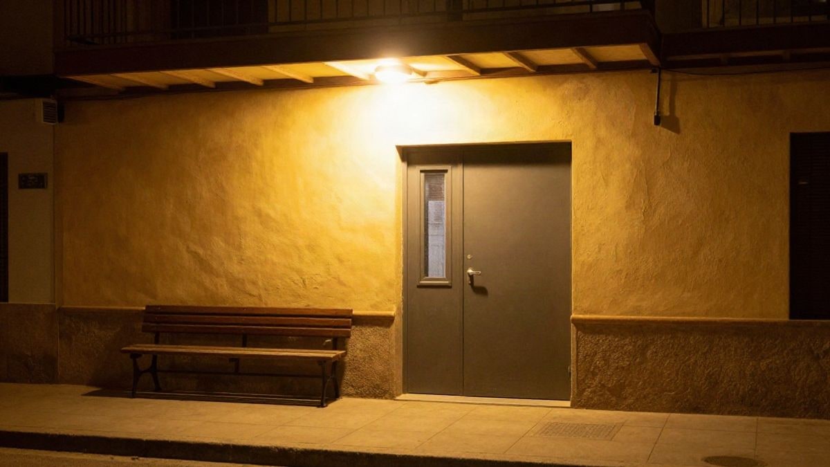 Illustrative image: entrance of a community centre lit by street lamps at night