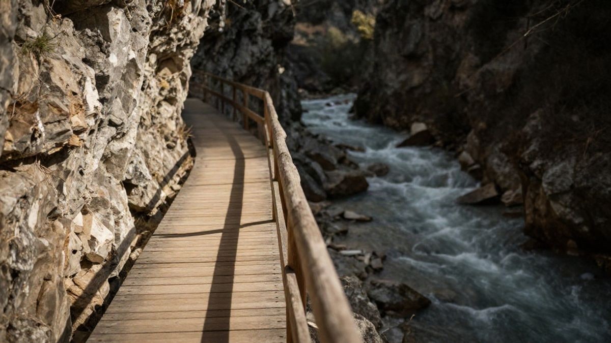 Imagen ilustrativa: pasarela de madera sobre un desfiladero rocoso con un río al fondo