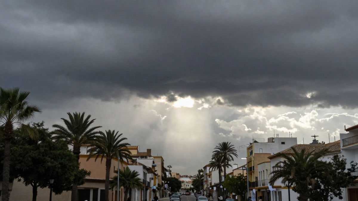 Imagen ilustrativa: cielo tormentoso sobre una calle genérica con palmeras y edificios bajos