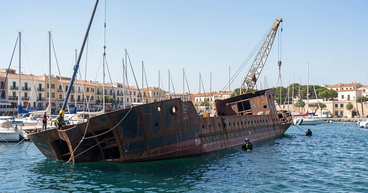 Rusty hull of the semi-submerged Willow ship in Benalmádena's marina