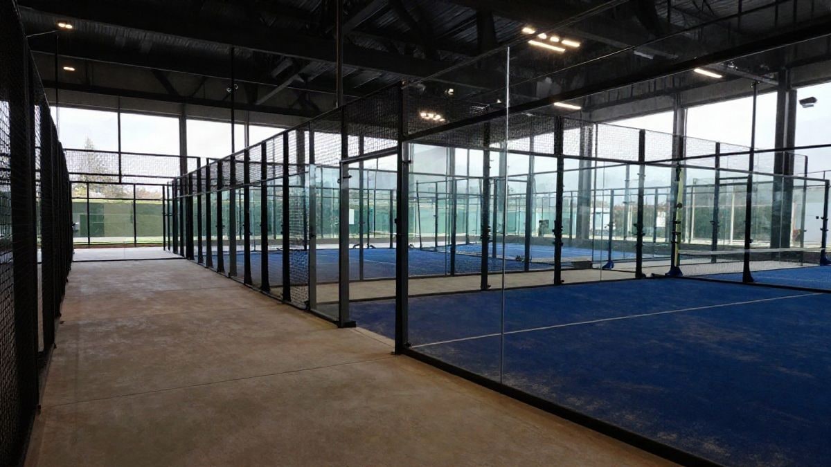 Imagen ilustrativa: pistas de pádel con cerramientos de cristal en un centro deportivo moderno