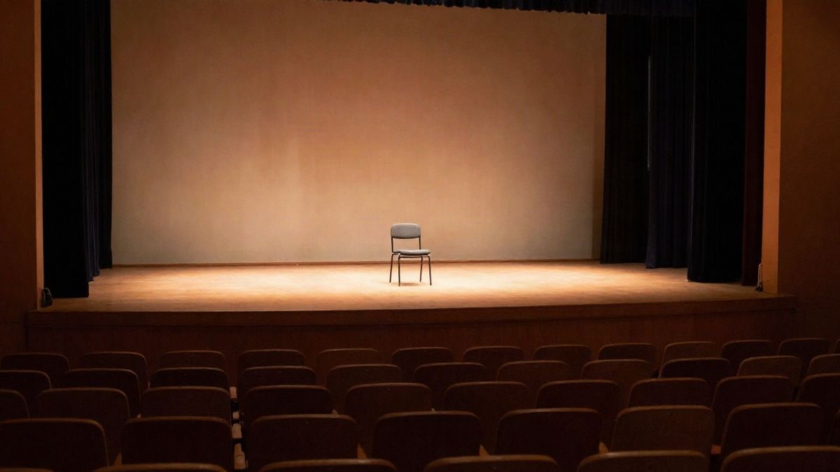 Illustrative image: stage of a school auditorium with a chair and a spotlight