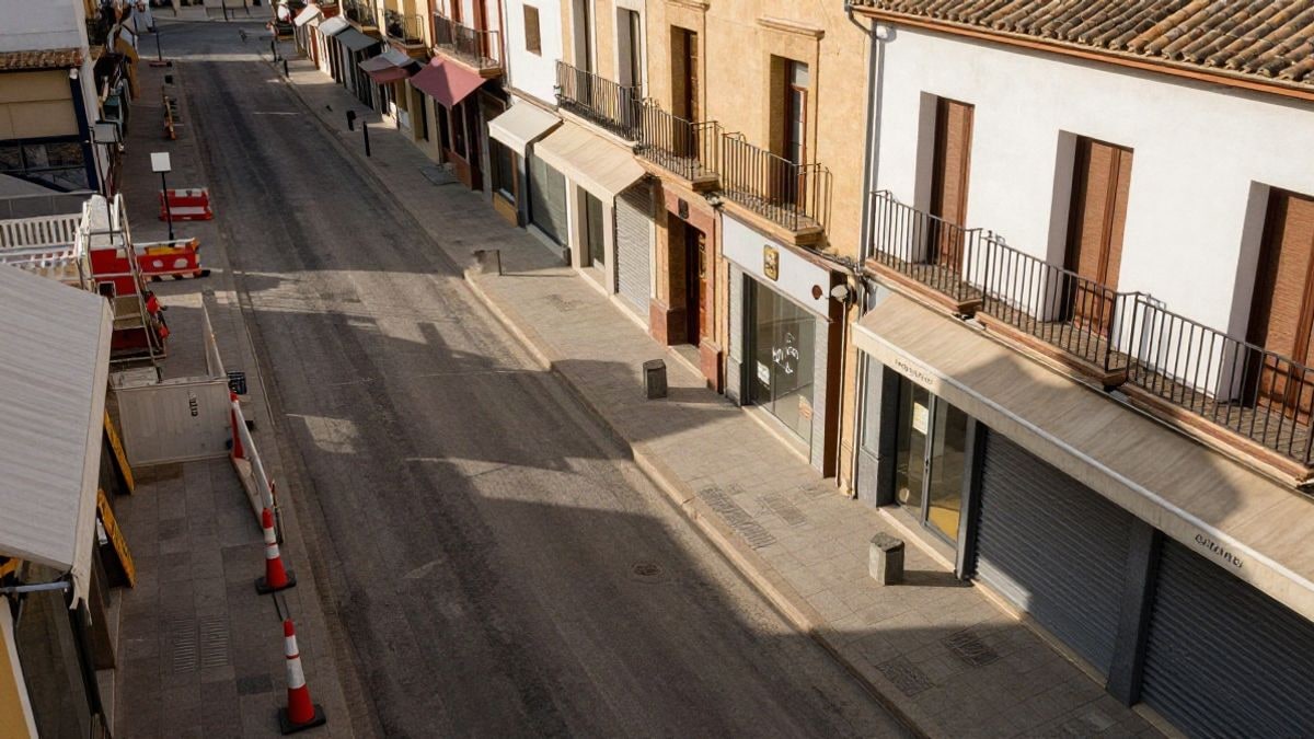 Imagen ilustrativa: vista cenital de una calle comercial con comercios y vallas de obra