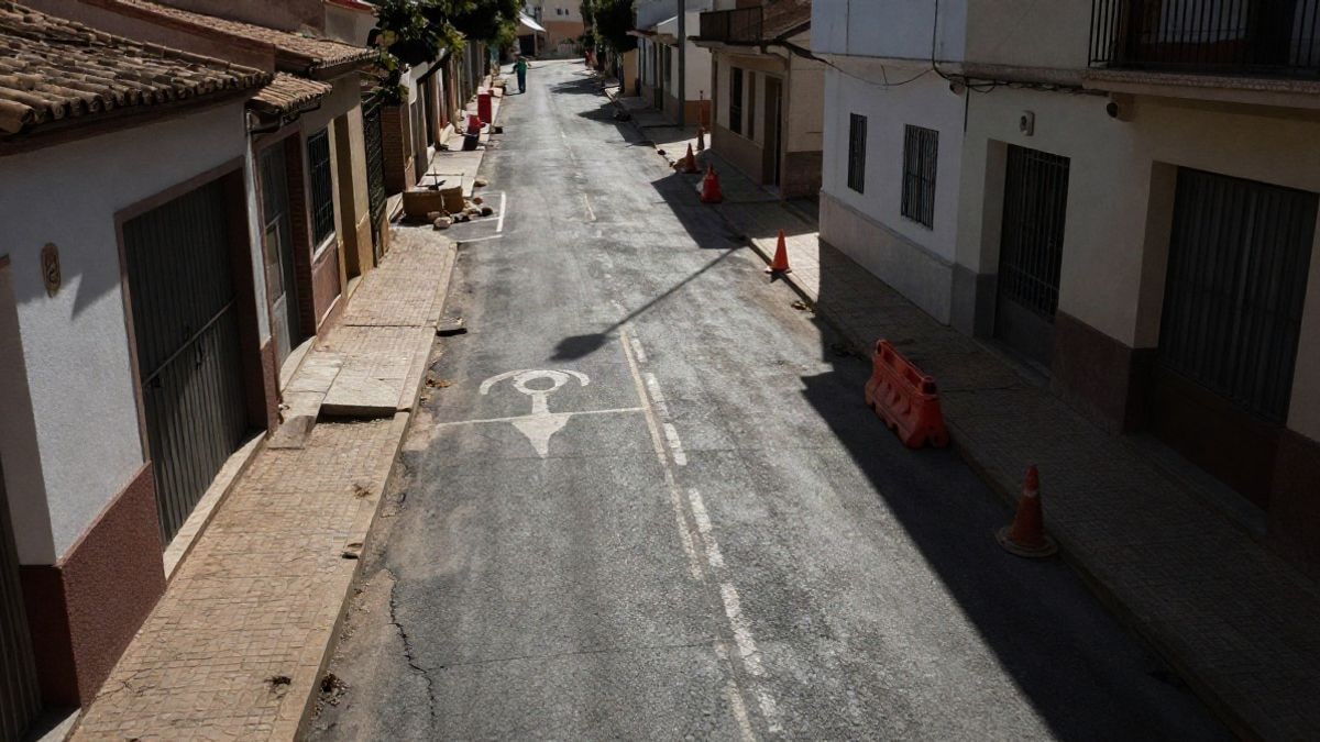 Illustrative image: view of a residential street with deteriorated asphalt and construction cones, sunset light