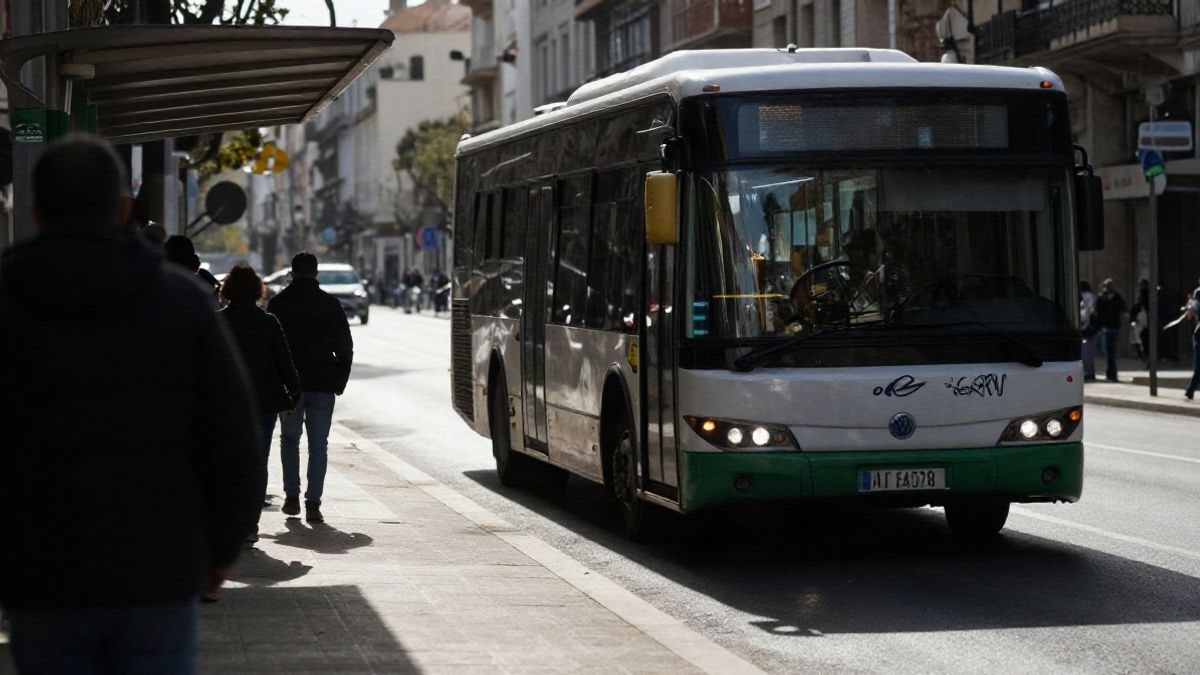 Imagen ilustrativa: autobús urbano híbrido acercándose a una parada en una ciudad costera al atardecer.