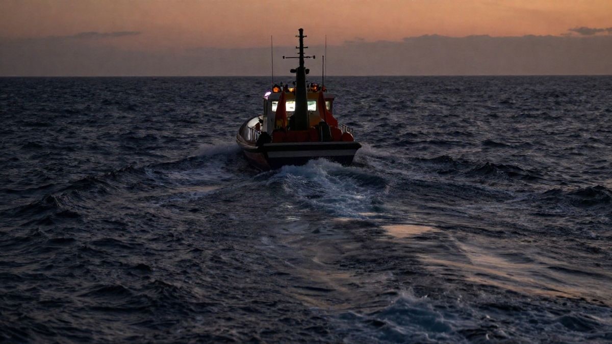 Imagen ilustrativa: una embarcación de rescate navega al atardecer por aguas oscuras