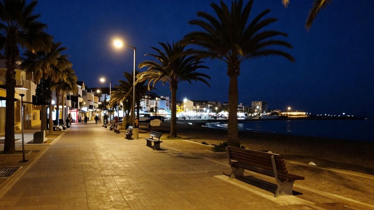 Imagen ilustrativa: paseo marítimo nocturno con farolas encendidas y palmeras