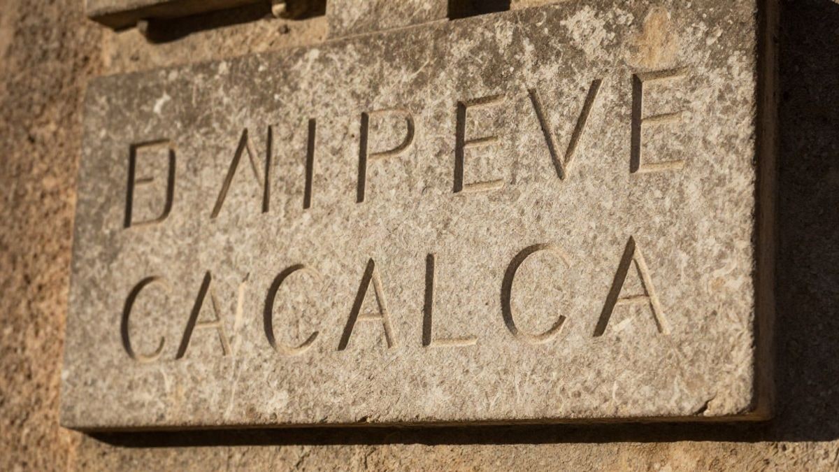 Imagen ilustrativa: detalle de una placa de piedra con inscripciones sobre una pared rugosa
