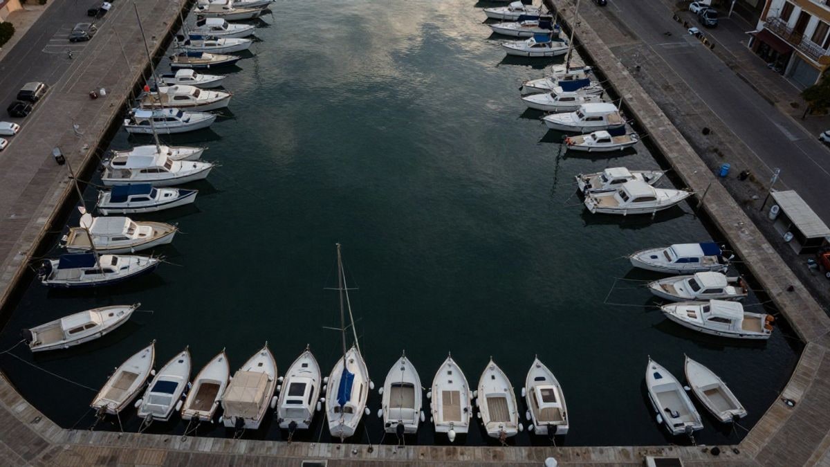 Imagen ilustrativa: vista cenital de una marina mediterránea con embarcaciones y pantalanes vacíos