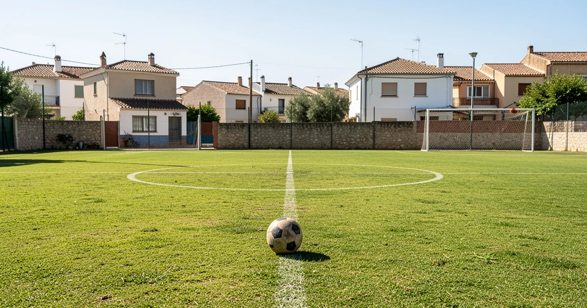 Empty football pitch in Arroyo de la Miel, Benalmádena, with a ball on the grass.