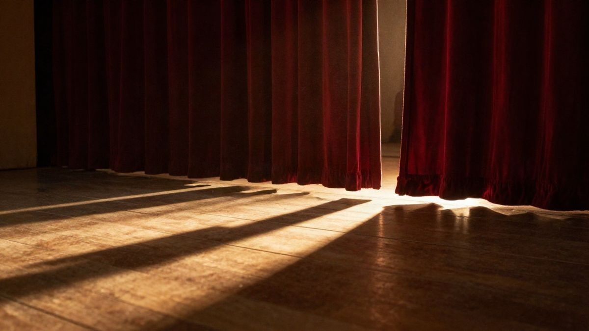 Illustrative image: empty theatre stage backlit at sunset, with long shadows on the wooden floor.