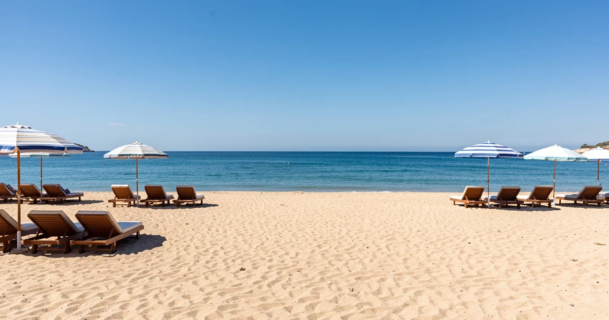Playa de Estepona con cielo despejado y sombrillas vacías