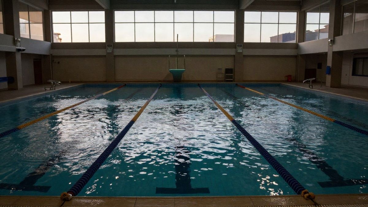 Imagen ilustrativa: una piscina cubierta municipal vacía con calles de agua al atardecer