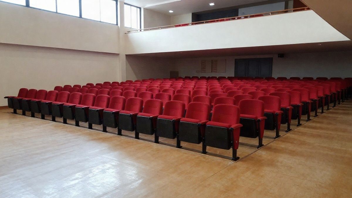 Imagen ilustrativa: interior de un auditorio vacío con nuevas butacas rojas y suelo de vinilo recién instalado.