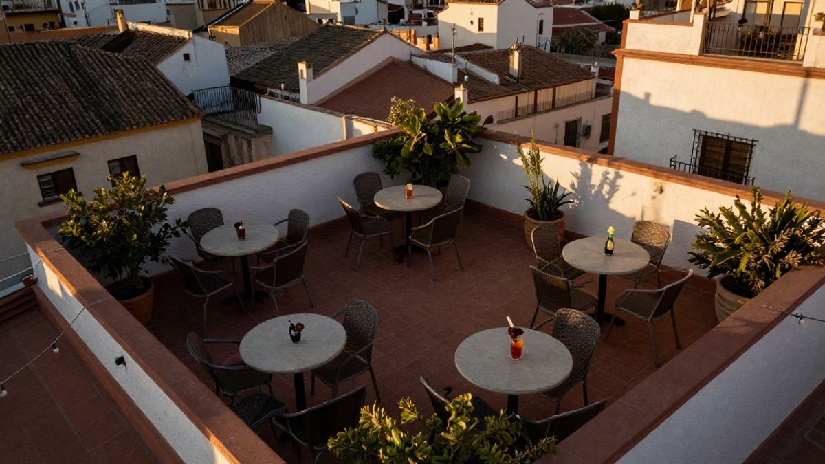 Imagen ilustrativa: vista cenital de una terraza en una azotea con mesas y sillas vacías al atardecer
