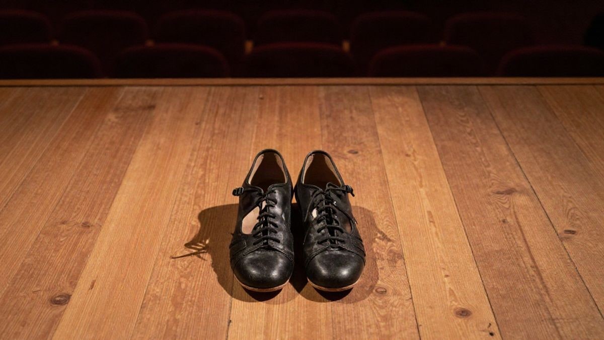 Imagen ilustrativa: vista cenital de un escenario con zapatos de baile flamenco y sombras alargadas